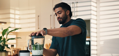 Man using a blender to make his drink