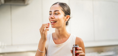 Woman about to take a Magnesium pill